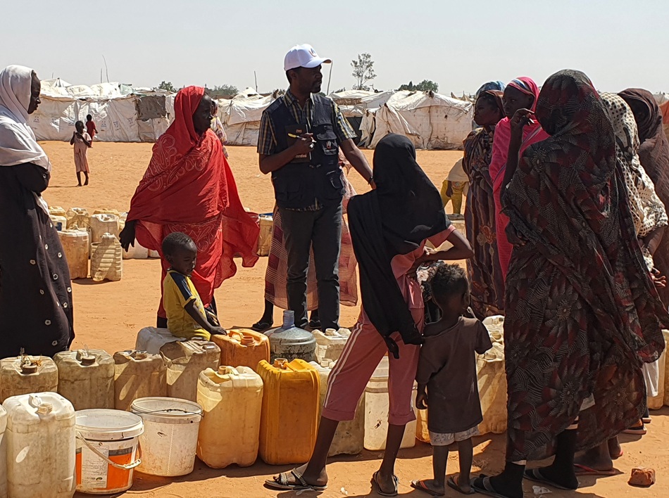 People waiting in line at water truck.